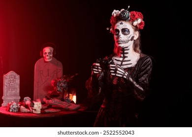 Woman playing videogames with controller at Day of the Dead event to remember the deceased. Lady enjoying games with gamepad during Mexican holiday of remembrance for those who have passed