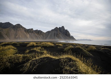 Zonsopgang Stokksnes kaap zee strand en Vestrahorn berg met zijn weerspiegeling op nat zwart vulkanisch zand oppervlak, IJsland. Prachtig natuurlandschap, populaire reisbestemming.