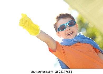 Boy, freedom and superhero with flying outdoor for fantasy game, play or pretend character with portrait. Kid, mockup person and action fist imagination for child development, adventure and halloween
