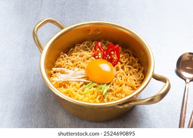 拉麵或辣味拉麵，在傳統的韓國麵條鍋中淋上蛋黃、辣椒和蔬菜。供應韓式泡麵。非常適合食譜、文章、目錄。