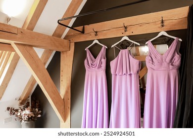 Lilac bridesmaid dresses - set of 3 hanging in barn dressing room
