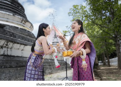 Songkran festival is funny water festival for long holiday in Ayuttaya  Thailand . young women wearing Thai dress traditional  happiness to playing  water during this festival.