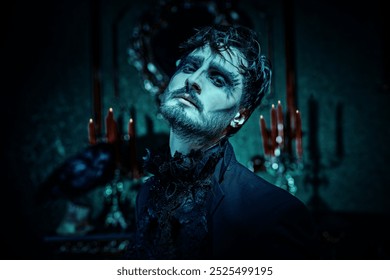 Domnul Întunecat. Halloween. Un bărbat brunet elegant, într-un costum negru, cu jabot și machiaj artistic negru, stă cu tristețe într-o cameră întunecată de epocă, cu lumânări. Fantezie.