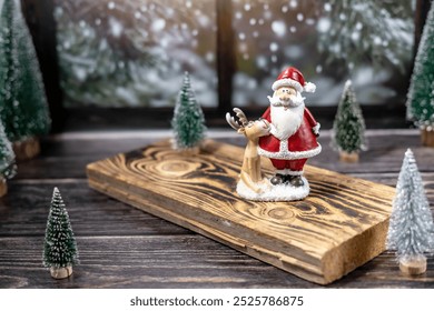 Sinterklas dan rusa kutub dari keramik, pohon Natal di papan kayu dekat jendela, kartu Natal, dekorasi rumah