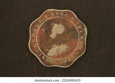 Tampilan dekat koin 4 Anna dari India Britania yang menggambarkan George V, Raja Kaisar, 1920.