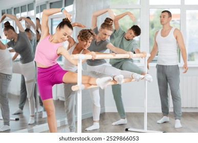 Pose de balé grand batman - meninas e meninos em uma aula de coreografia estão aprendendo movimentos de balé no estúdio