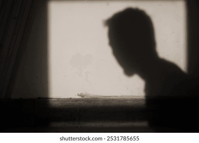 schwaarz-wäiss Foto vun engem Mann vun der Säit op enger Mauer portraitéiert. Surabaya Indonesien, 17. Oktober 2024.