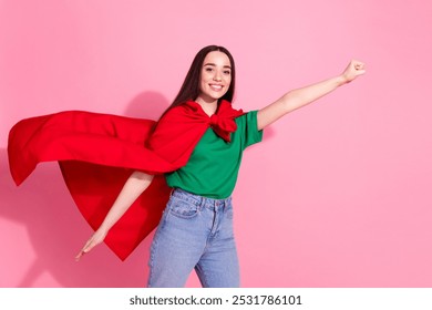 Ảnh người phụ nữ quyến rũ tích cực mặc áo phông xanh lá cây siêu anh hùng áo choàng giơ nắm đấm khoảng trống nền màu hồng tách biệt