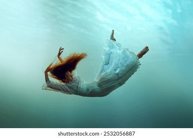 Image créative représentant une jeune fille rousse calme en lévitation sous l'eau mettant en valeur l'harmonie entre l'homme et la nature. Concept de surréalisme, de beauté, de mystère et de fantaisie, de liberté