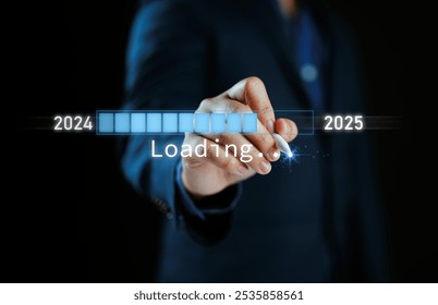 Un homme d'affaires appuie sur une barre de téléchargement virtuelle avec un indicateur de progression de chargement le soir du Nouvel An, transformant l'année 2024 en 2025.