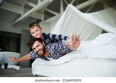 Padre, avión y niño en casa para crear vínculos, relajarse y jugar juntos en la cama el fin de semana. Familia, avión y niño feliz para apoyarse, desarrollarse y divertirse durante la infancia con juegos, avión y superhéroe