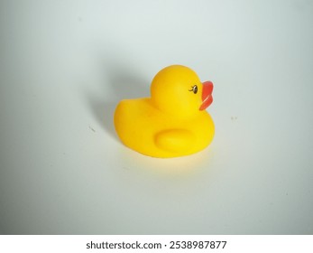 closeup of a children's toy in the form of a duck made of yellow rubber on an isolated white background
