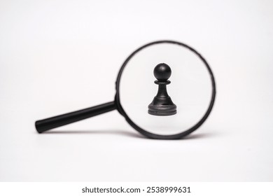Magnifying glass focusing on a Single Chess Pawn on white background