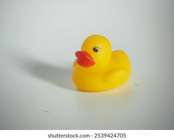 closeup of a yellow rubber duck toy on a white isolated background