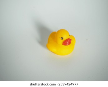 closeup of a yellow rubber duck toy on a white isolated background