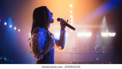 Talent Show Performance: Portrait of a Young Female Pop Singer on a Stage with Colorful Neon Lighting. Musician Singing a Powerful Solo, Poring Her Heartfelt Emotions into Beautiful Music