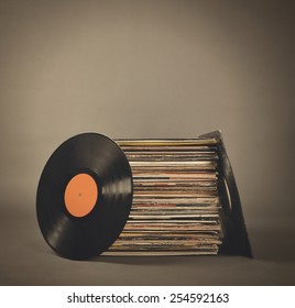 パーティーやエンターテイメントのコンセプトのために、孤立したグレイの背景に古いレトロなビニールレコードのスタック。