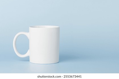 ถ้วยสีขาวสำหรับชาหรือกาแฟ วางอยู่บนพื้นหลังสีฟ้า ภาพระยะใกล้