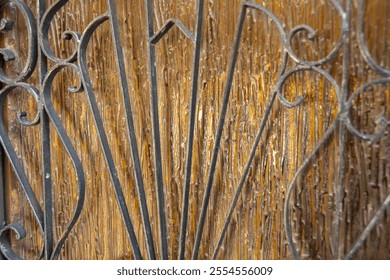 Nahaufnahme vun engem ornamentéierten Eisentor mat komplizéierte Blummenmuster. E schéint Beispill vu Vintage-Handwierk a kënschtlereschem Design.
