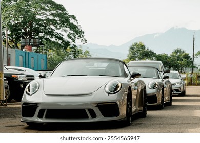 山々の景色を望むスポーツカーが、サーキット走行に向けて準備を整える。