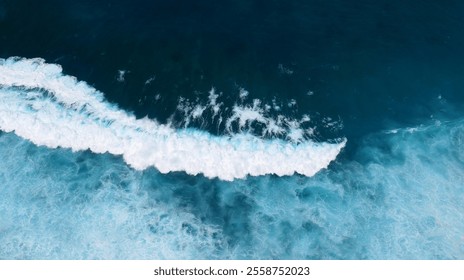 Meereslandschaft mit dunklem Ozeanhintergrund, Wellen spritzen gegen Felsen. Tropischer Strand im Sommer, draußen am Meer. Blaues Wellenmuster auf der Wasseroberfläche. Türkisfarbenes Meerwasser, weiße Wellen spritzen tiefblaues Meer