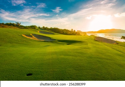 Búnkers de arena en el hermoso campo de golf al lado del océano al atardecer, hora del amanecer.