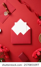 Elegante busta rossa con biglietto vuoto, circondata da rose, nastro e timbro di ceralacca. Idea regalo per matrimonio o San Valentino.