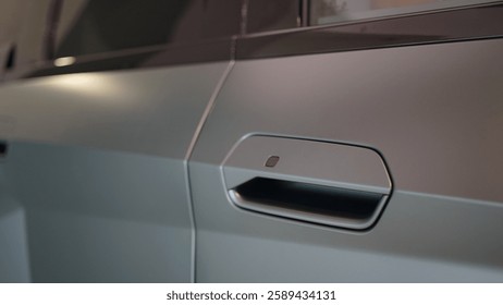 Een close-up van een deurgreep van een gepantserd voertuig met een matte afwerking. Het moderne ontwerp met een verzonken handgreep en aanraakgevoelige knop benadrukt een futuristische en hightech uitstraling.