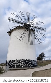 Um moinho de vento tradicional na Argentina, com arquitetura rústica e paisagem deslumbrante. Ideal para temas de viagens, história e patrimônio.