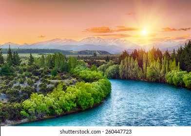 Beautiful sunset over the bend of the river Clutha with Southern Alps peaks on the horizon, New Zealand