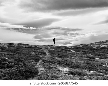 นักเดินป่าคนเดียวเดินอยู่ในหุบเขา Grimsdalen พร้อมวิวเทือกเขา Rondane ในประเทศนอร์เวย์