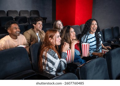 Grupa mladih ljudi uživa u filmu u kinu, dijeleći smijeh i osmijehe dok grickaju kokice i odlično se zabavljaju