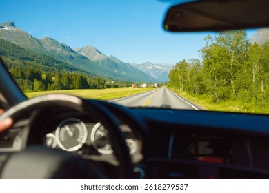 View of the road from inside the car. Traveling by car. View of the road and the panel of the car. Driving on an asphalt road. Man behind the wheel. Wallpaper, postcard, background.