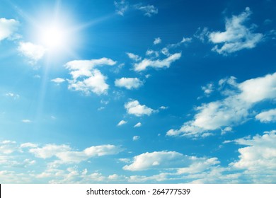 Blauwe lucht met wolken en zon.