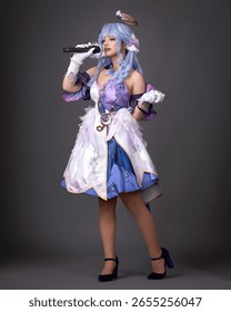 Mavi cosplay kıyafetleri ve peruk takan kız, karanlık arka planda stüdyoda poz veriyor.