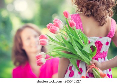 Wanita dan anak dengan karangan bunga dengan latar belakang kabur hijau. Konsep liburan keluarga musim semi. hari perempuan