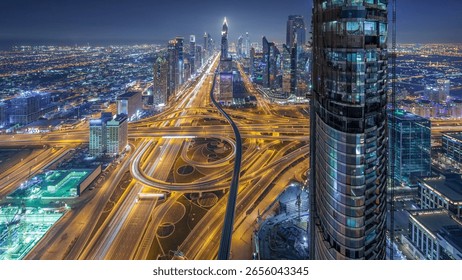 Scenic Dubai downtown skyline at night timelapse. Rooftop view of traffic on Sheikh Zayed road with numerous illuminated towers.