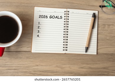 OBIECTIV 2026 cu caiet, ceașcă de cafea neagră și pix pe masă de lemn, vedere de sus și spațiu pentru copie. An Nou Fericit, rezoluție, listă de activități, strategie și concept de plan