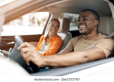 Happy young black couple enjoying relaxed moment while driving car together
