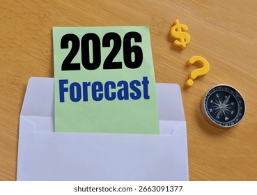 Previziuni pentru anul 2026 într-un plic cu hârtie verde de mentă ca notă de predicții de piață. Perspective pentru anul 2026. O busolă, un semn de întrebare și un simbol al banilor pe fundalul unei mese de lemn.