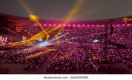 Kız grubu Blackpink'in ışıklı çubuklarla dolu hayranlarıyla dolu büyük stadyumdaki kpop konseri