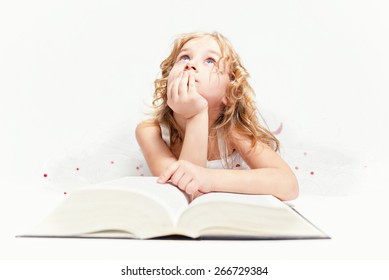 Cô bé xinh đẹp nghĩ về việc đọc trong cuốn sách.