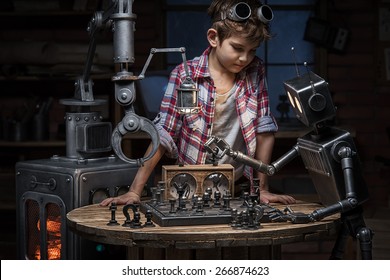 少年メカニックは、夕方にスタジオで 2 つのロボットがチェスのゲームをプレイしているように見えます