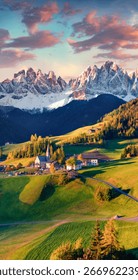 Vertikal Hierschtvue op d'Duerf Santa Maddalena virun der Geisler- oder Odle-Dolomitengrupp. Wonnerschéinen Sonnenënnergang an den Dolomitenalpen, Italien, Europa. Schéinheet vun der Landschaft am Hannergrond.