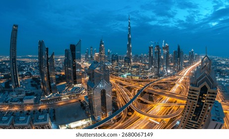 Modern skyscrapers and busy evening highways night in luxury downtown of Dubai city. Top aerial view from tower rooftop. Road junction traffic. Fisheye lens. Dubai, United Arab Emirates