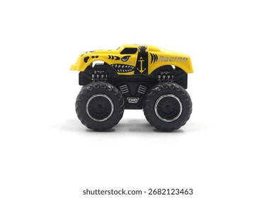 Gelb-schwarzes Mini-Monstertruck-Spielzeug vor weißem Hintergrund