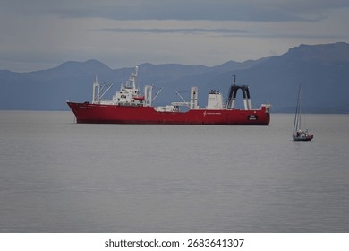 Grande nave e piccola imbarcazione nella baia di Ushuaia, Argentina