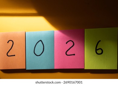 2026. Nový rok. Barevné lepící papírky s číslem „2026“ napsaným černě.
