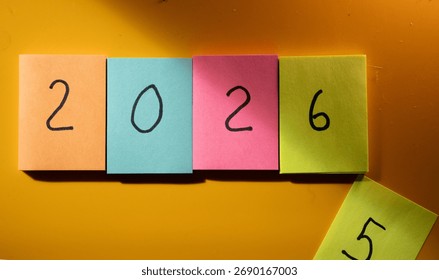 2026. Nový rok. Barevné lepící papírky s číslem „2026“ napsaným černě.
