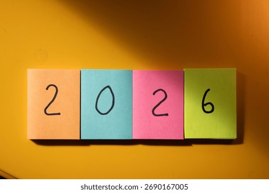 2026. Nový rok. Barevné lepící papírky s číslem „2026“ napsaným černě.